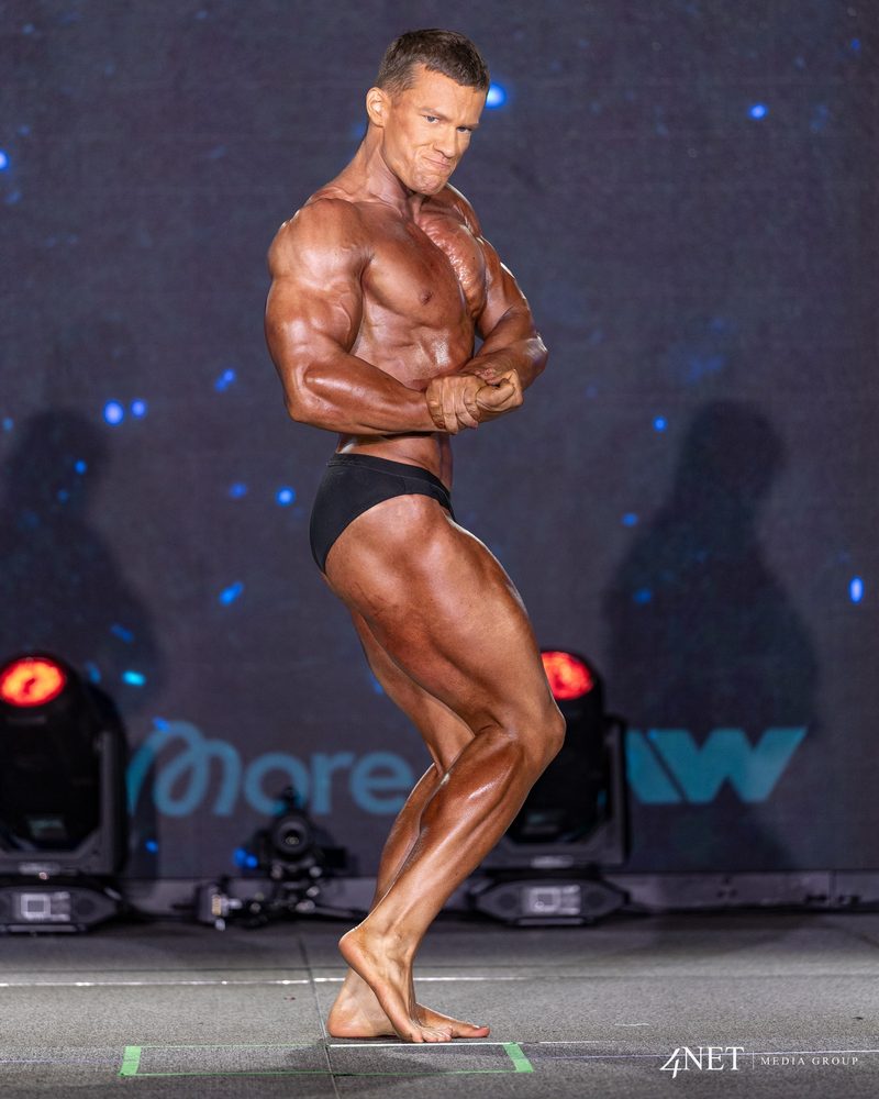 Cameron Kennison in a side chest pose in Classic Physique.